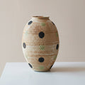 Close up of medium beige textured vase with polka dot pattern