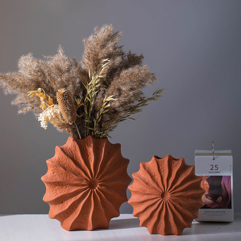 Textured ceramic sunburst vase with dried flowers