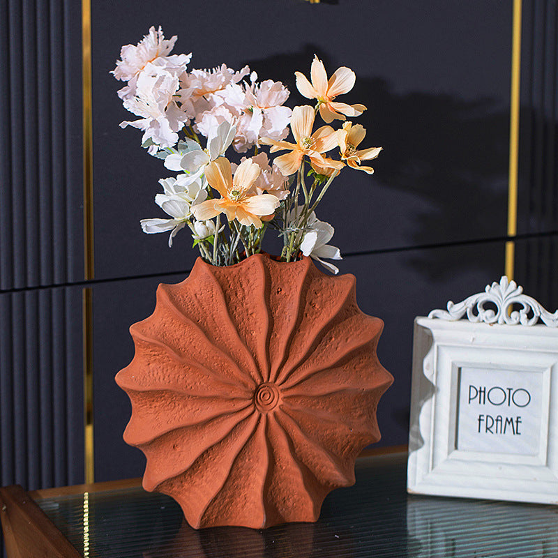 Ceramic sunburst vase styled with artificial flowers