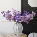 Textured clear glass vase with purple orchids
