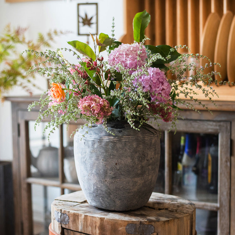 Lifestyle shot of large concrete vase with floral arrangement