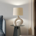 Textured cream resin table lamp with organic sculptural base on side table