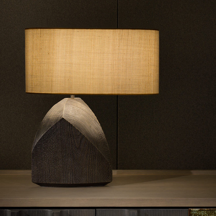 Front view of textured dark resin table lamp lit