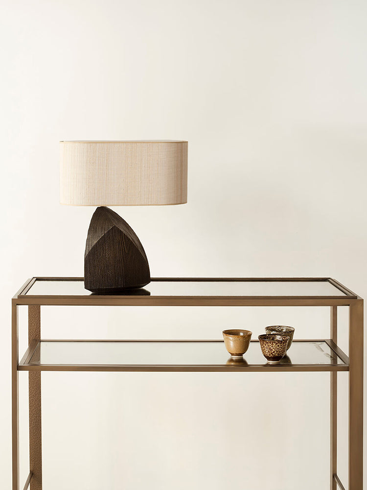 Context shot of dark resin lamp on glass console table