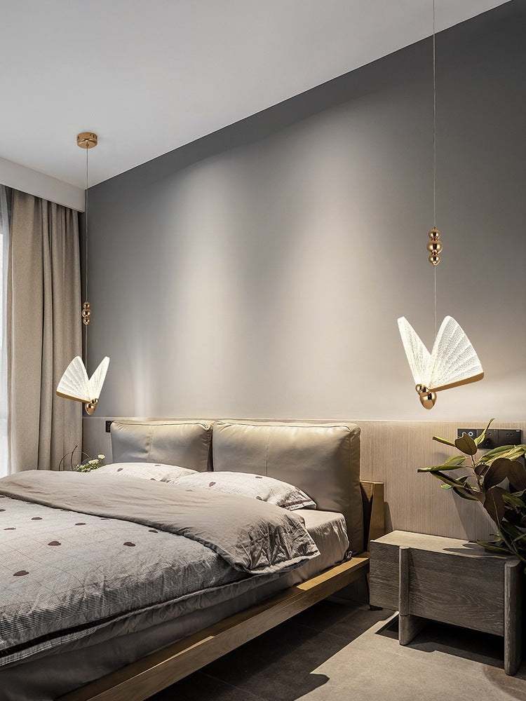Pair of gold butterfly pendants in modern grey bedroom