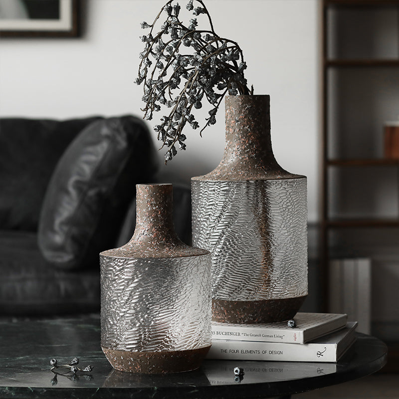 Textured glass and rustic stone vase duo on marble table with dried flowers