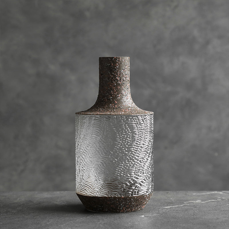 Large ripple texture glass vase with rustic finish standing on grey surface