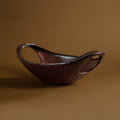 Side view of textured burgundy stoneware bowl with handles