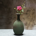 Textured green ceramic bottle vase with single red flower