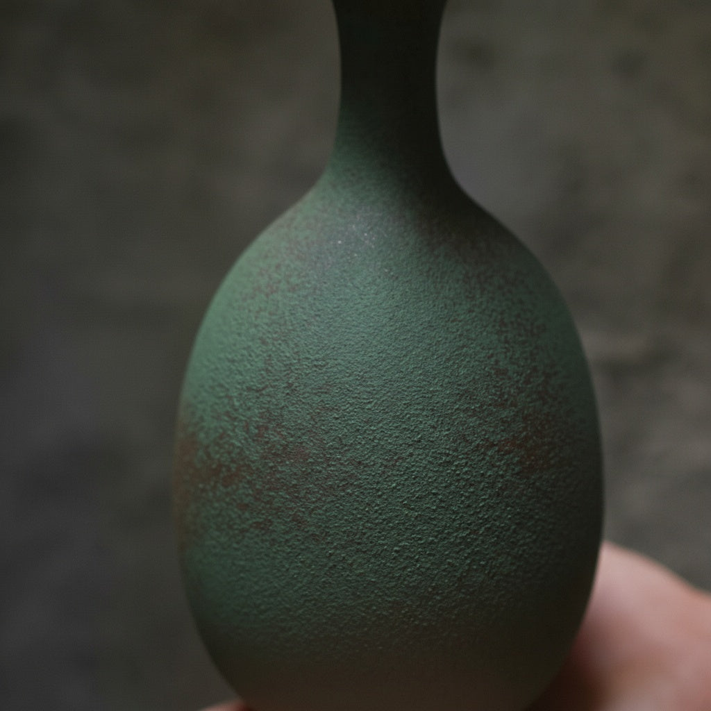 Close up detail of matte green texture on ceramic vase