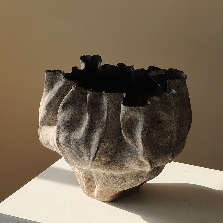 Empty folded grey ceramic vase side view