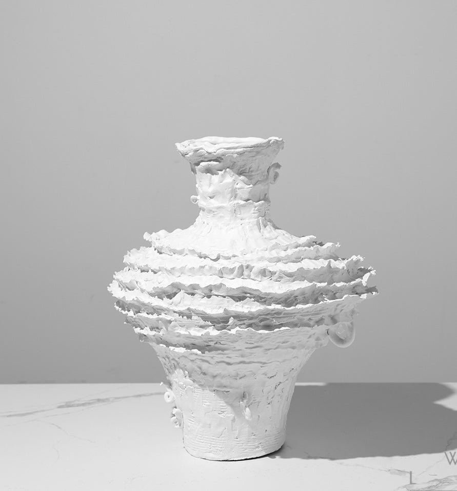 Angled view of white sculptural vase
