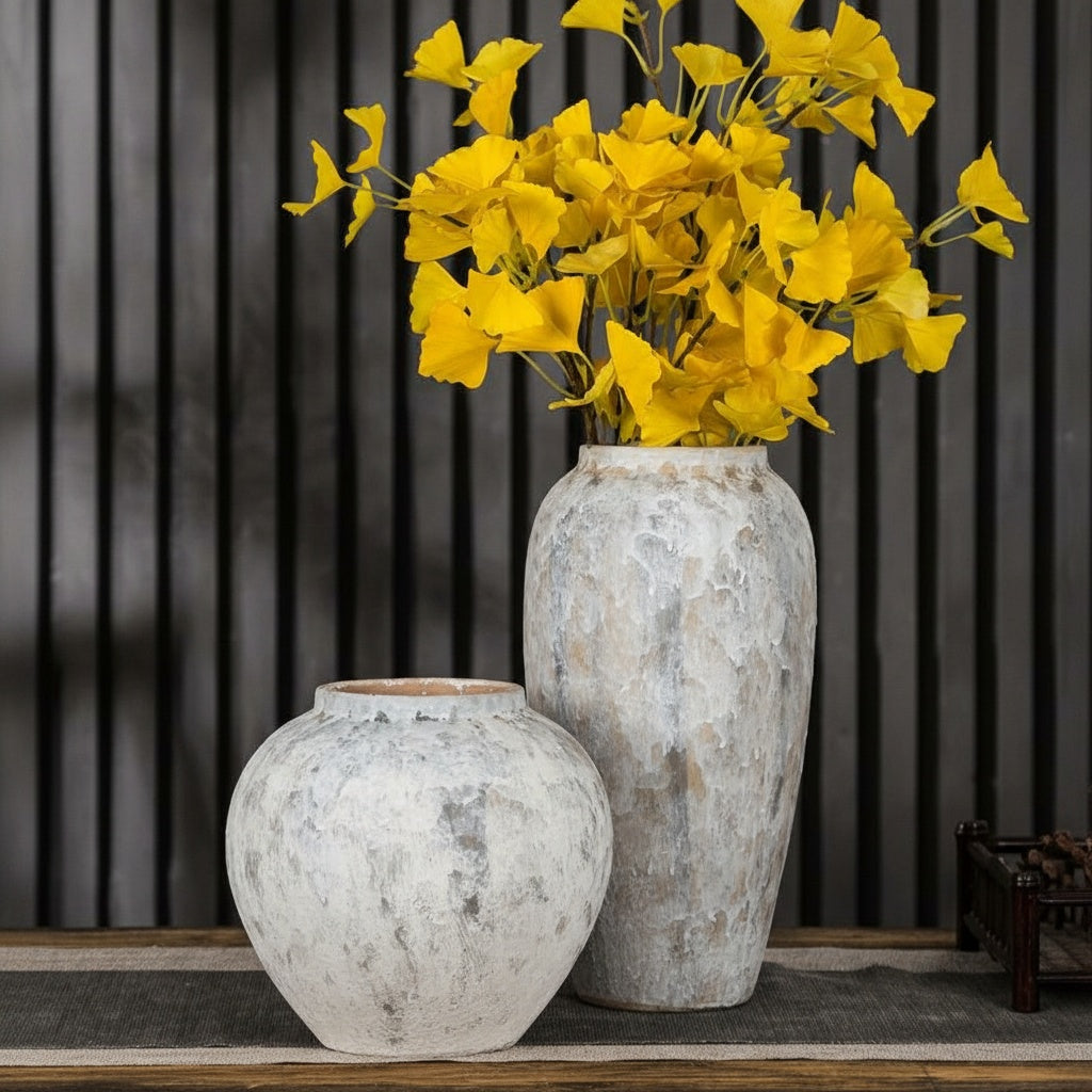 Textured matte white ceramic vases in tapered and globular shapes on table