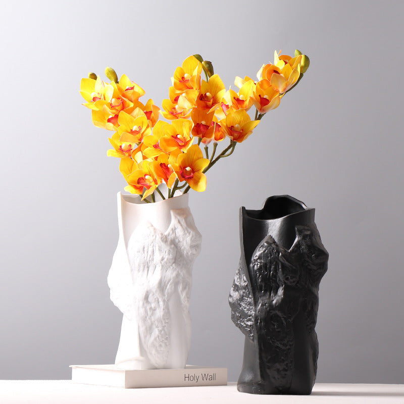 Black and white textured vases with yellow orchid arrangement