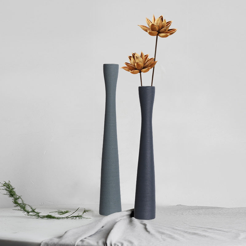 Two slender charcoal ceramic vases with dried flowers