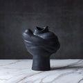 Side view of black textured porcelain vase showing organic form