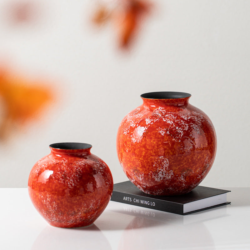 Two red ceramic vases on table