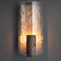 Front view of textured resin wall sconce lit