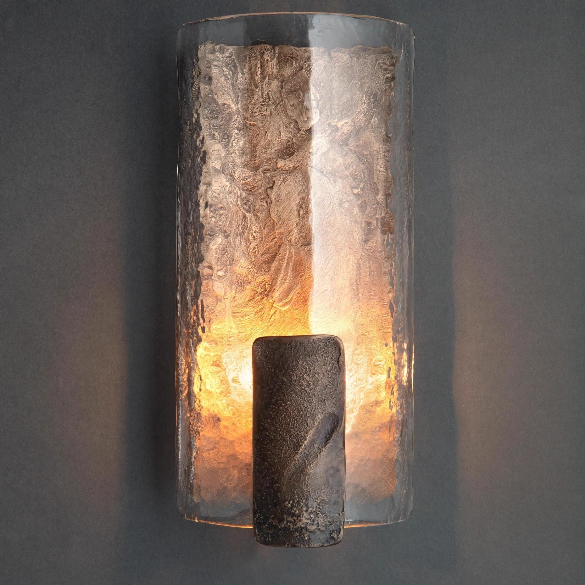 Front view of textured resin wall sconce lit