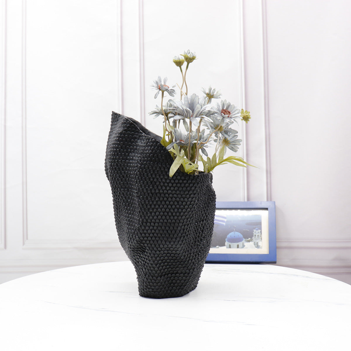 Black asymmetrical crumpled vase with flowers