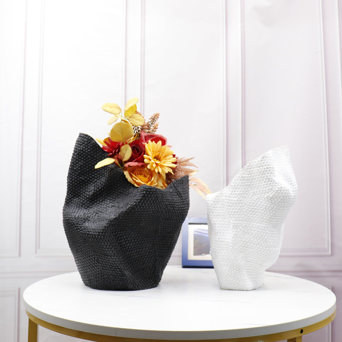 Black and white sculptural resin vases side by side