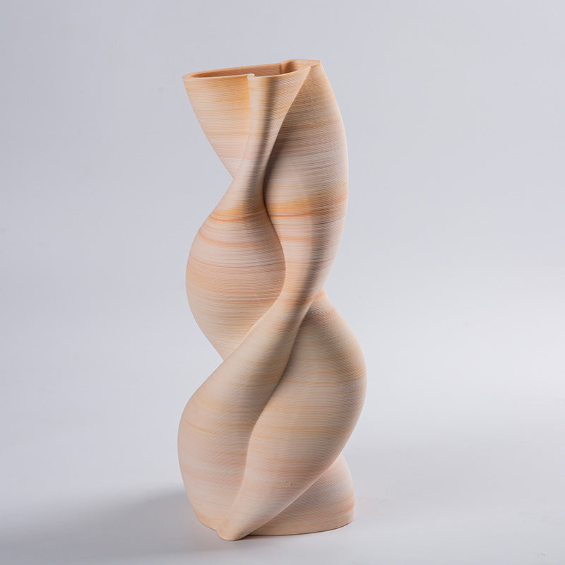 Side view of beige ceramic sculptural vase showing organic curves