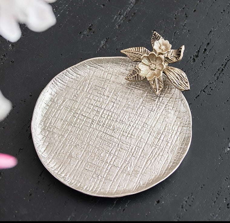 Overhead view of empty round silver tray showing woven texture and floral rim detail