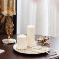 Silver vanity tray displaying white pillar candles and pearls in a luxury setting