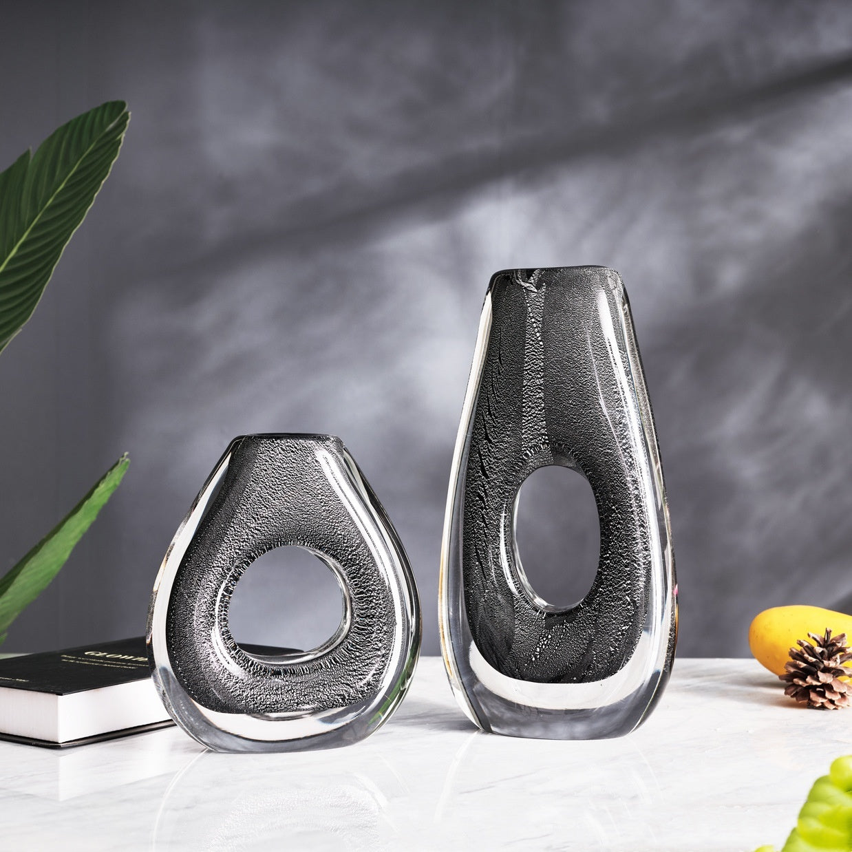 Pair of sculptural crystal vases on marble table