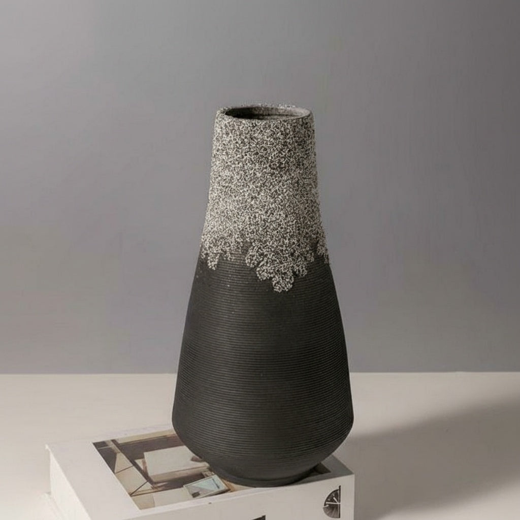 Black ceramic vase with ribbed texture and speckled neck detail