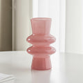 Pink tiered glass vase on a white table