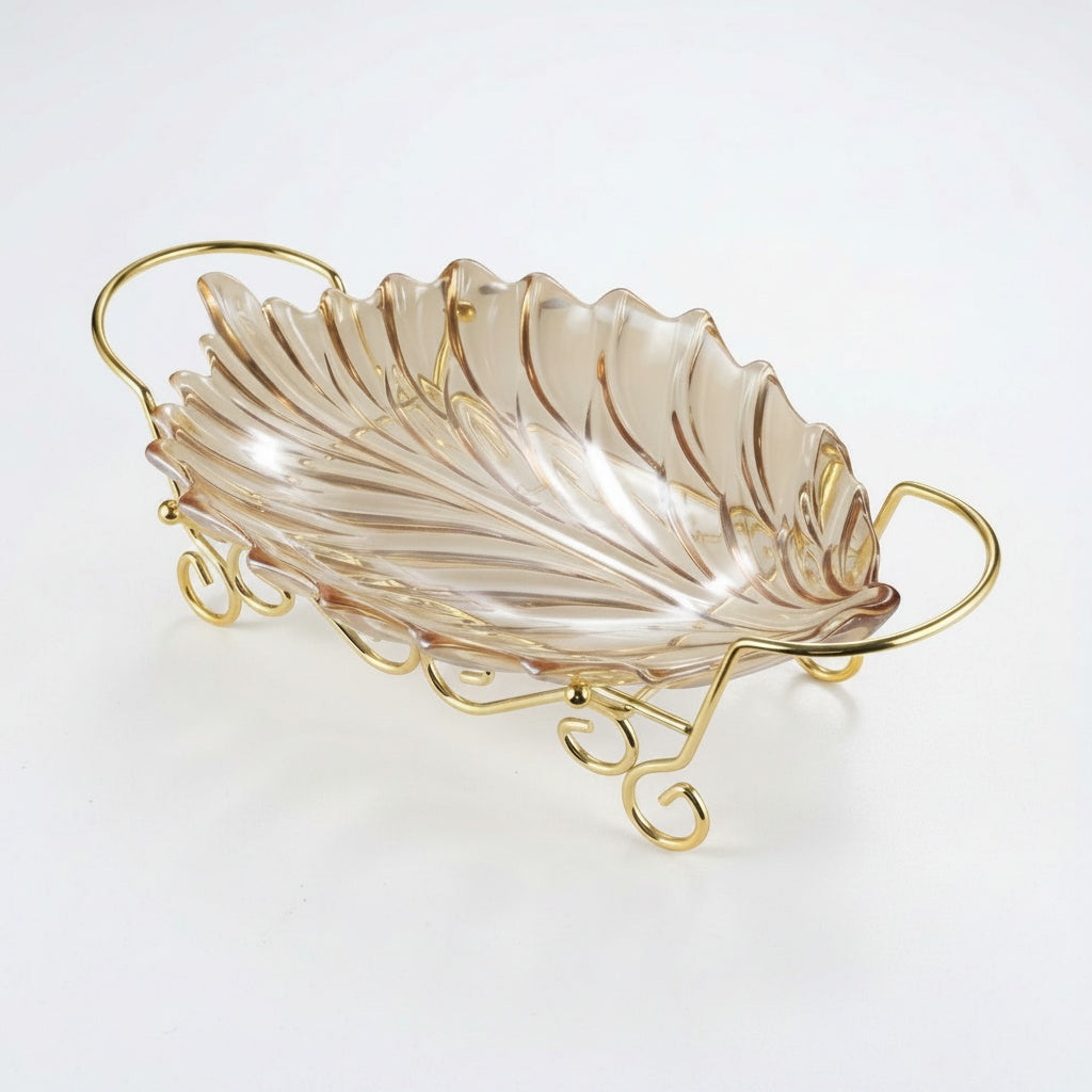 Empty tinted glass leaf shaped serving bowl on decorative gold metal stand