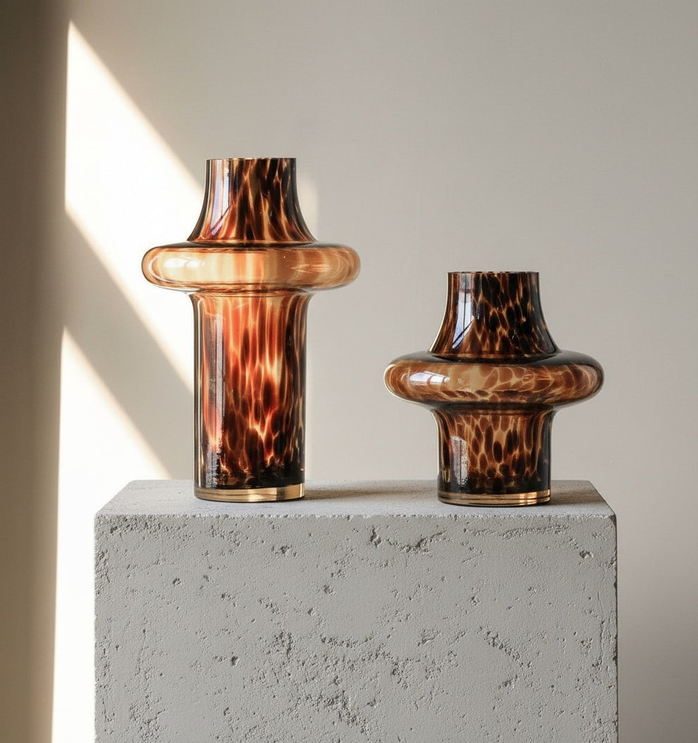 Two tortoise shell glass vases on white mantel