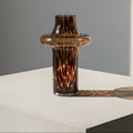 Top angle view of amber glass vase with light reflections