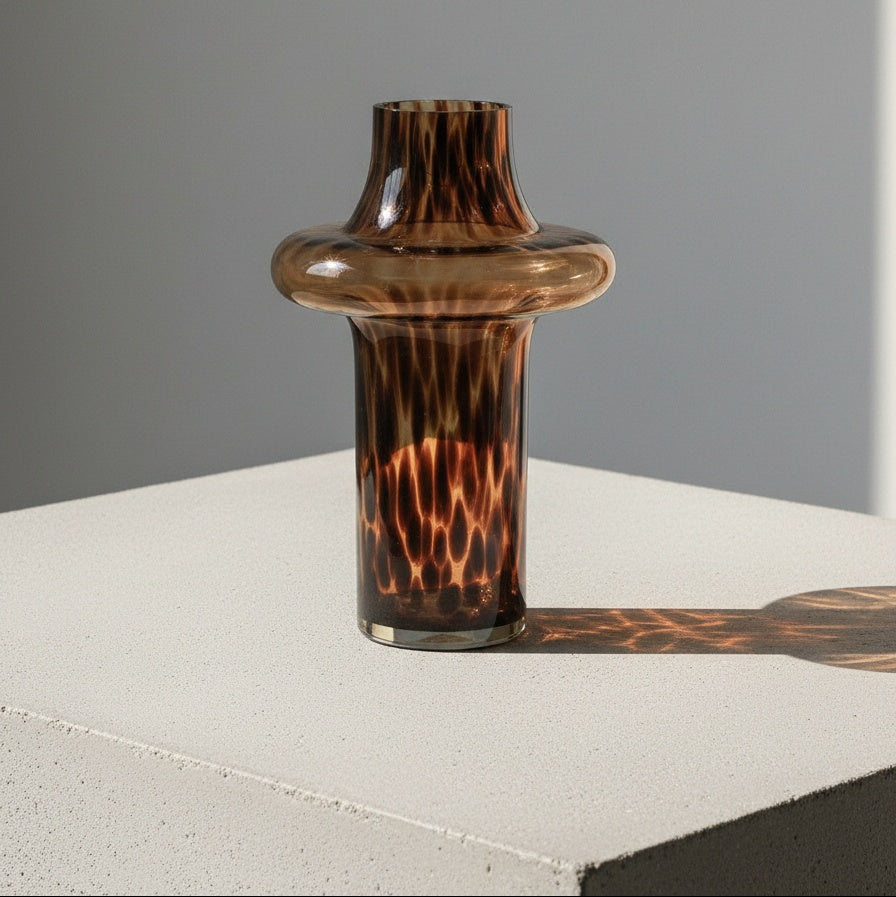Top angle view of amber glass vase with light reflections