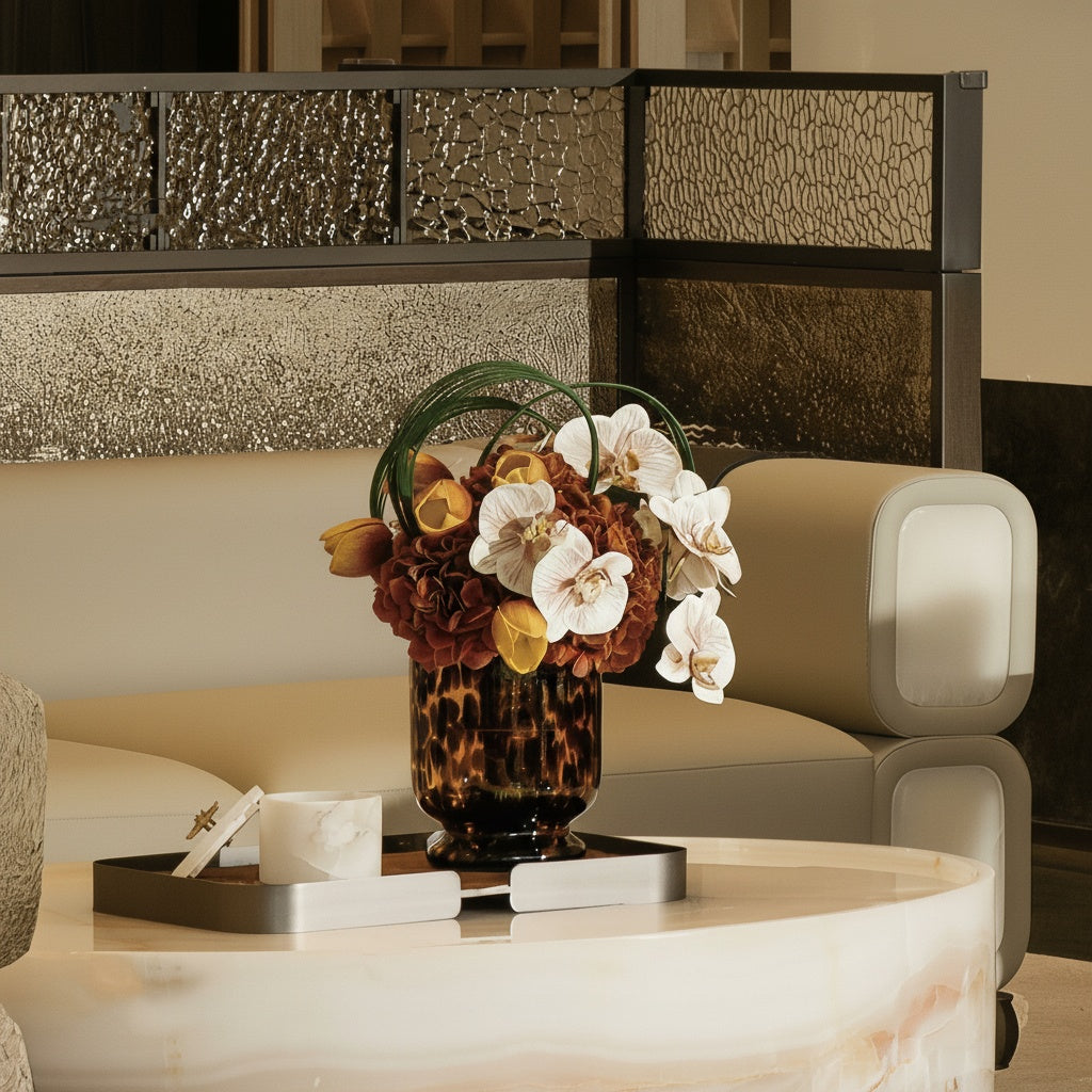 Tortoiseshell glass footed vase styled on a marble table with floral arrangement