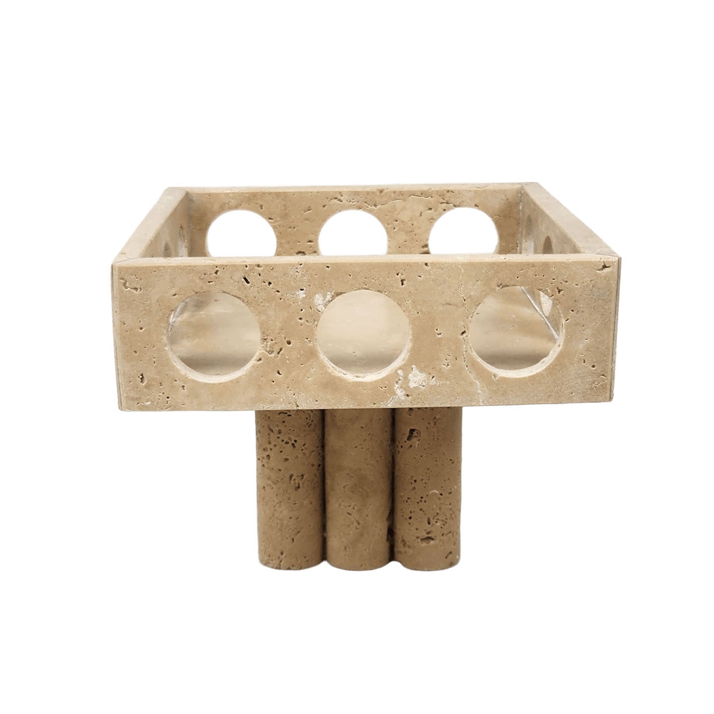 Front view of beige travertine footed bowl with circular cutouts