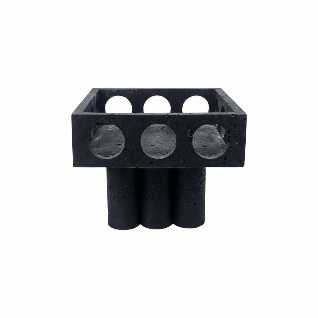 Front view of black porous stone footed bowl with geometric design