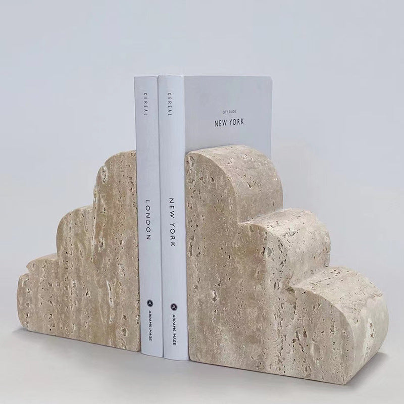 Pair of beige travertine bookends with a stepped cloud design standing upright