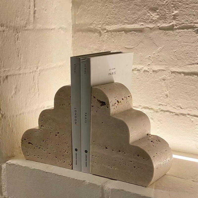 Side view of travertine stone bookends holding up hardcover books on a shelf