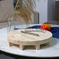 Travertine marble round footed display tray on table with glasses