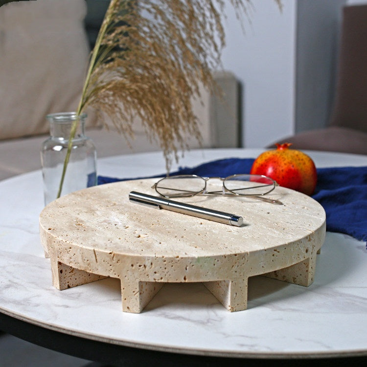 Travertine marble round footed display tray on table with glasses