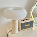 Angled view of travertine mushroom lamp on white console