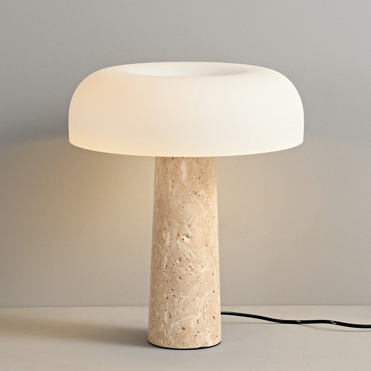 Studio shot of illuminated travertine mushroom lamp against grey background