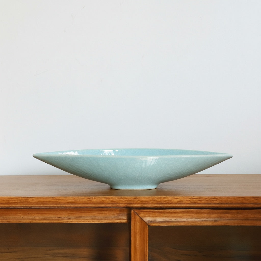 Turquoise ceramic boat bowl on wooden console