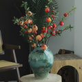 Turquoise reactive glaze ceramic urn vase with faux fruit branches