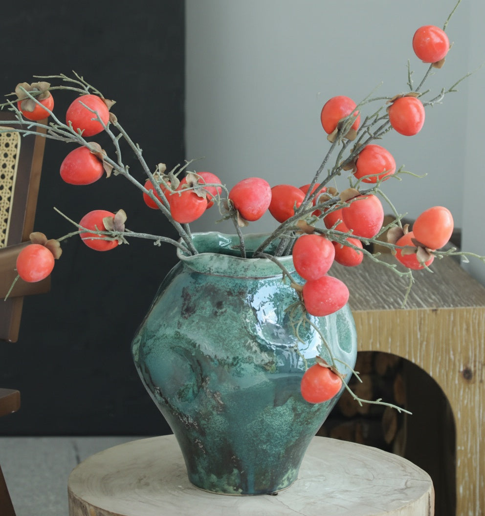Detail of turquoise glazed vase with persimmon branches