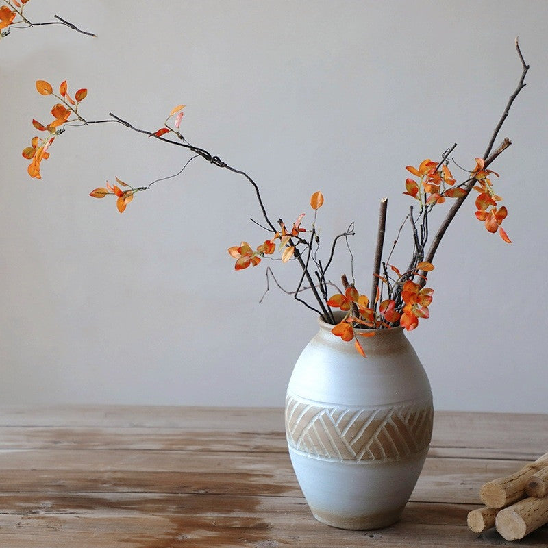 Rustic carved pottery vase on wooden table