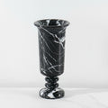 Detail of black marble pedestal vase with white veining