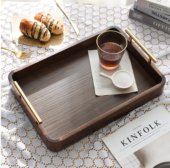 Top down view of wooden tray styling coffee glass, sugar, and pastries on a lace tablecloth